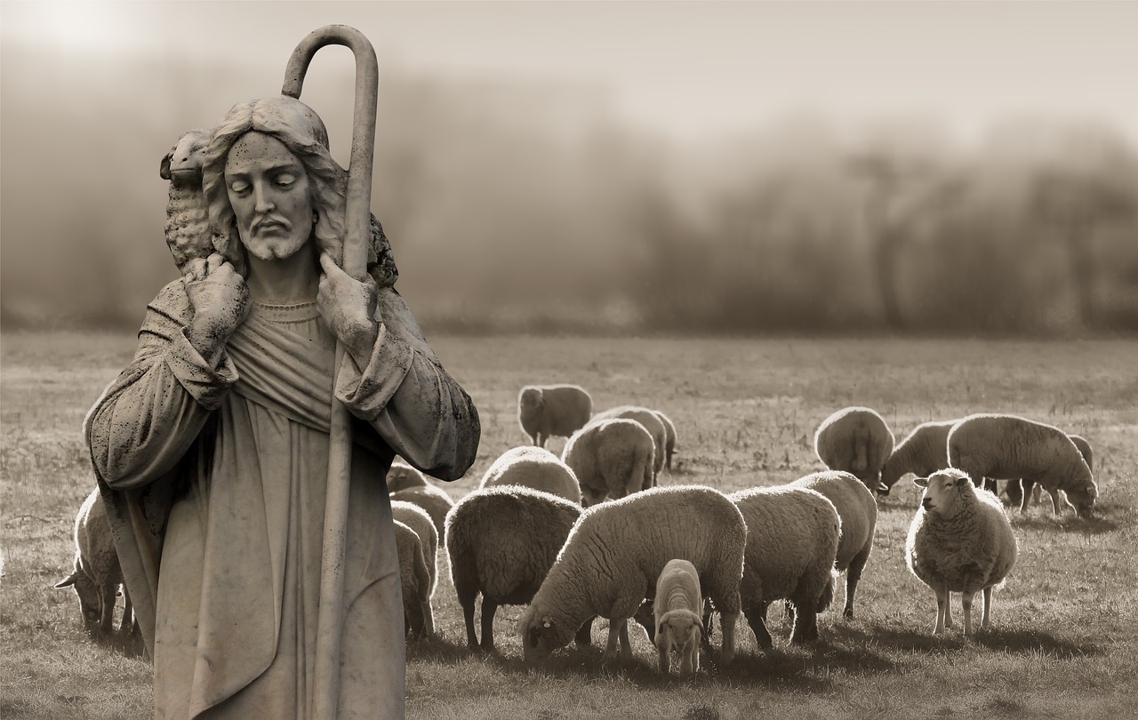 Jesus as the Good Shepherd carrying a sheep with a flock behind him.